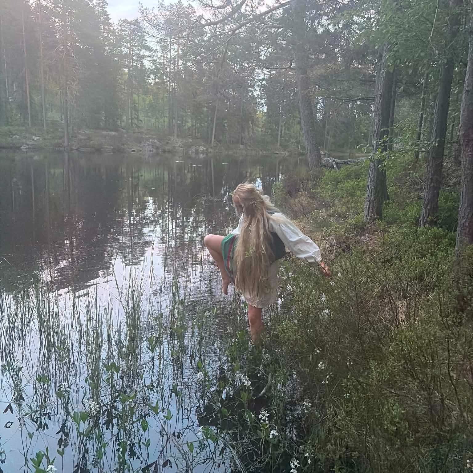 Bilde: Jente med langt hår i skogsvann